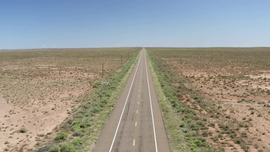 An aerial view of cars driving on a desert road