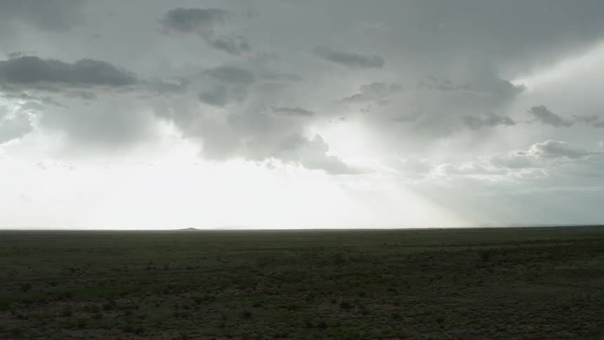Storm clouds over a flat plain of land