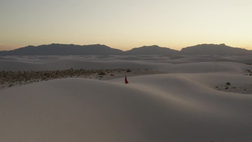 Aerial shot of a woman walking in a desert