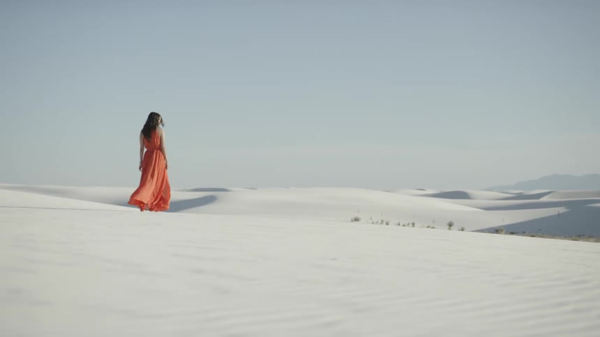 Women in red dress walking in sand