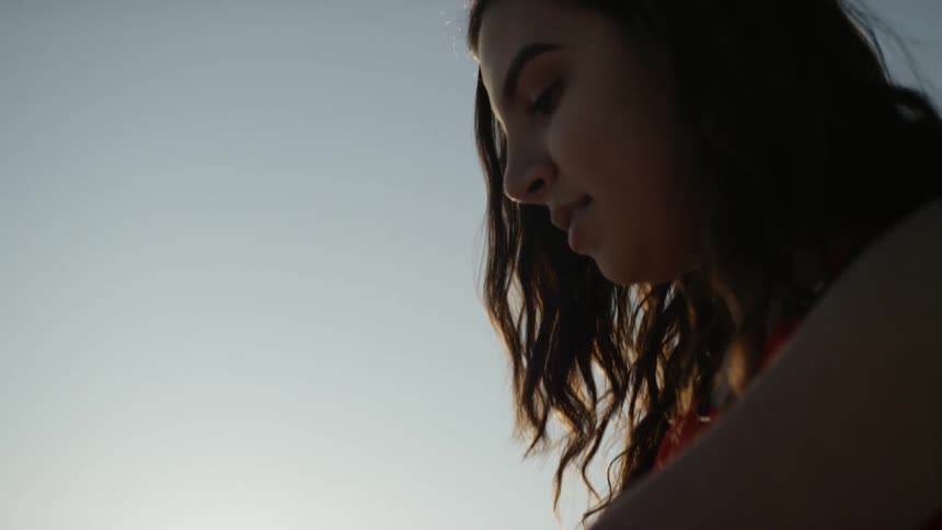 A woman is smiling and sitting outdoors