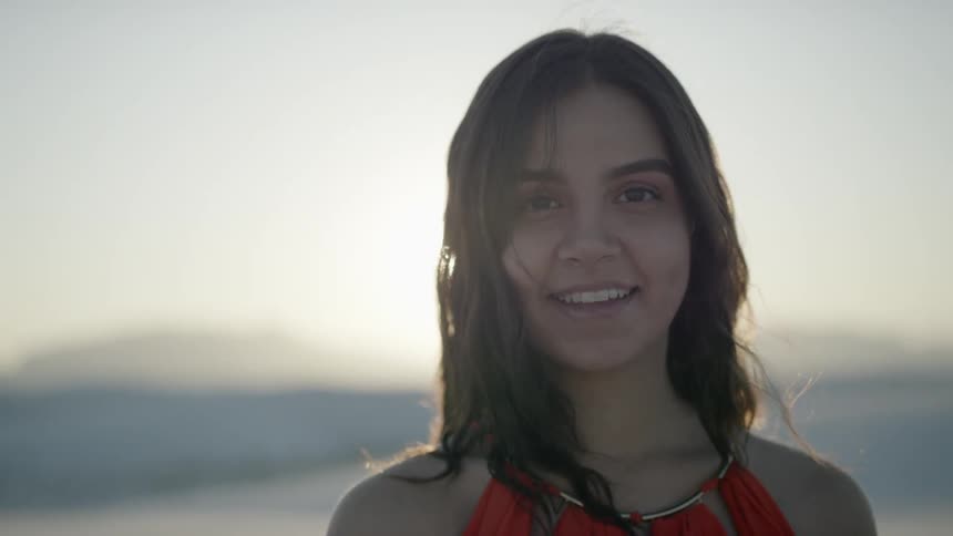 A woman wearing a red shirt smiles into the camera