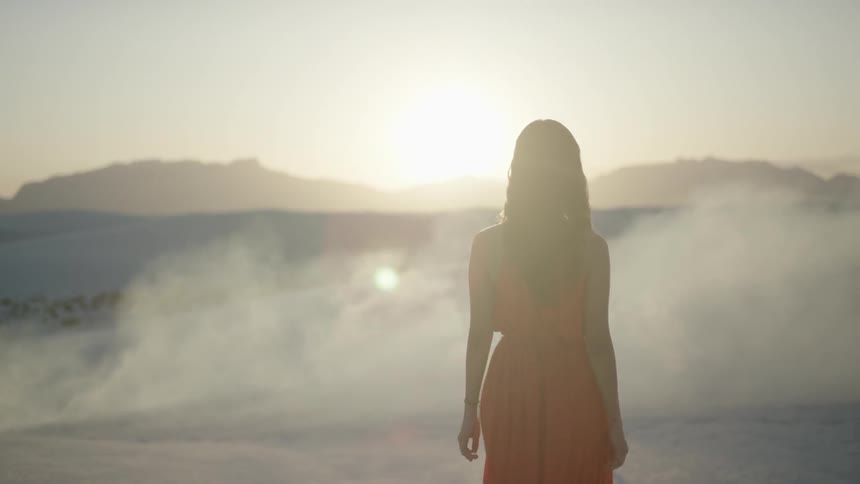 A woman walks through the sand