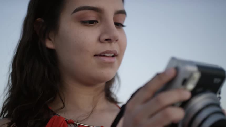 A woman looks at her camera