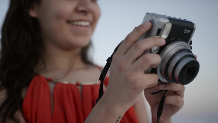 A woman smiles viewing photos on digital camera