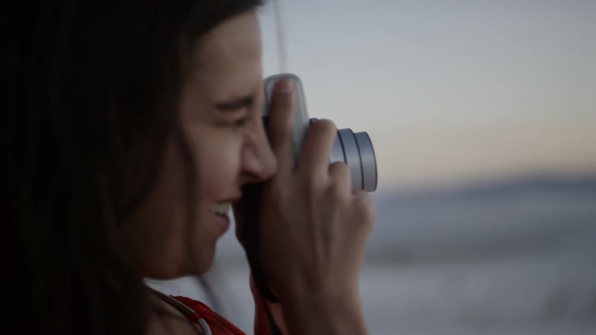 A woman takes photographs of nature with a digital camera