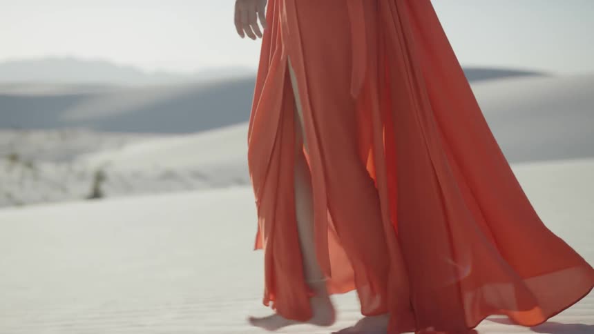 A woman walks across the sand