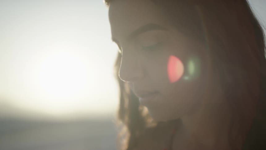 A woman looks at sand in her hands