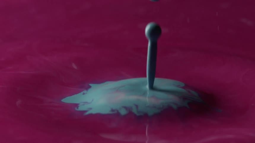 Turquoise paint splatters in to pink paint