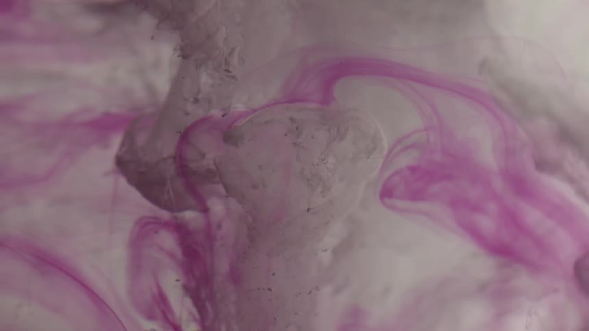 Pink and white liquids swirl together