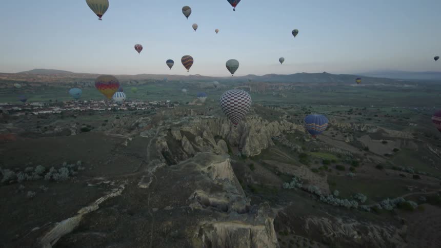 Hot air balloons fly above a canyon