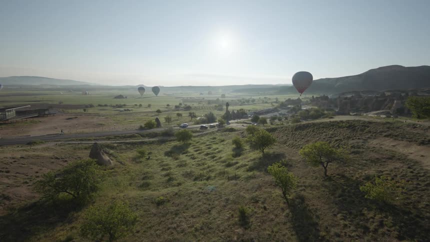 A few hot air balloons float in the sky