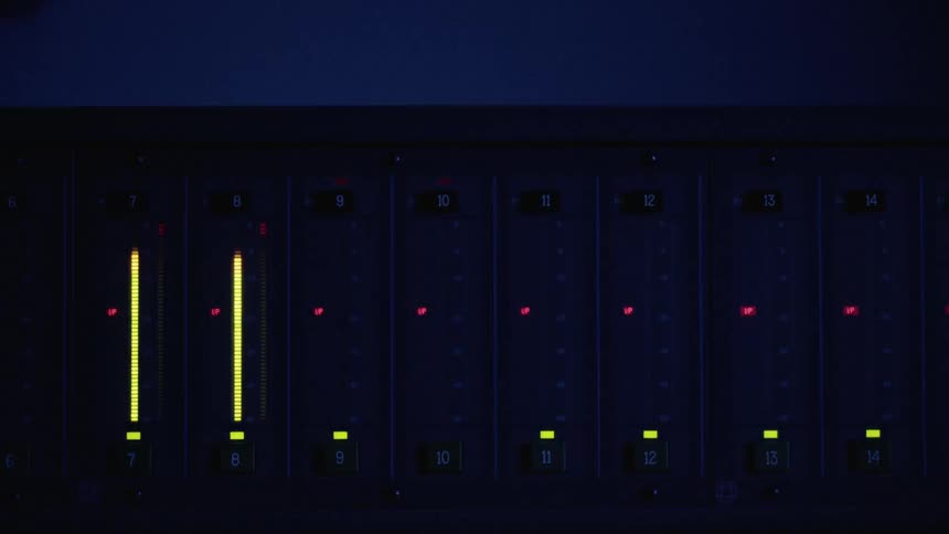 A sound mixing board with lights flashing