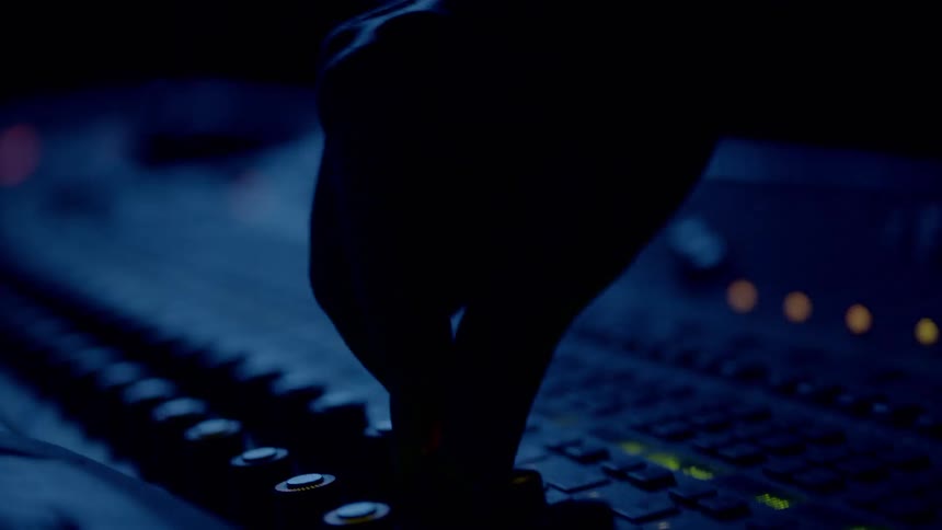 Mans hand operates the button of the device in the dim light studio