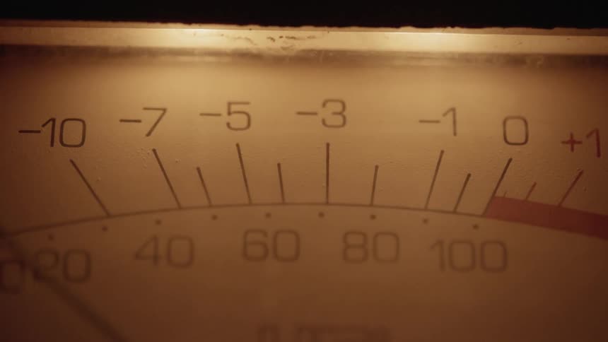 The needle of a volume unit meter swaying back and forth