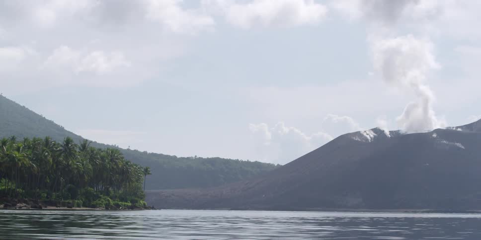 Passing by a wooded island with mountains in the distance