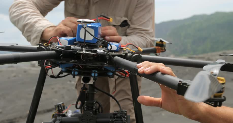 A man makes adjustments on a drone