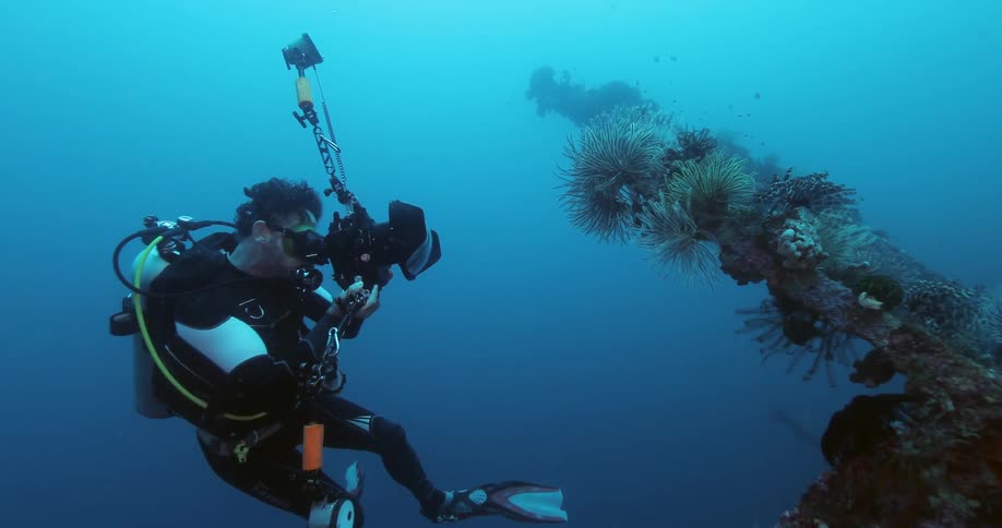 A scuba diver taking pictures of a reef