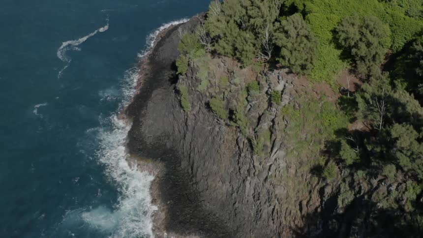 A promontory sits in a clear blue ocean
