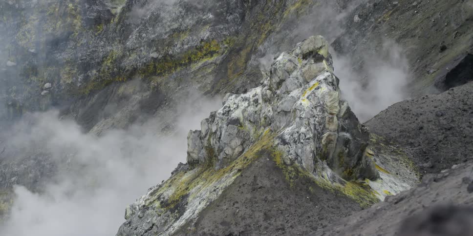 Mountains covered with green moss and snow standing in the fog