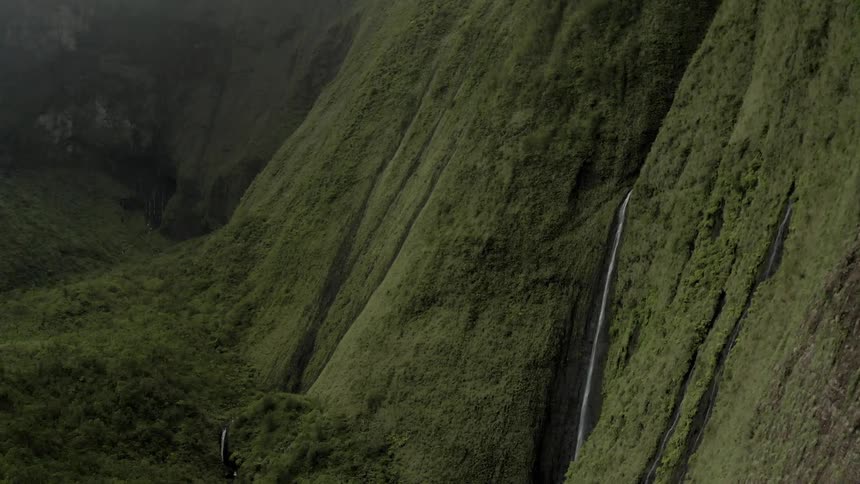 An aerial view of mountain cliff and waterfall