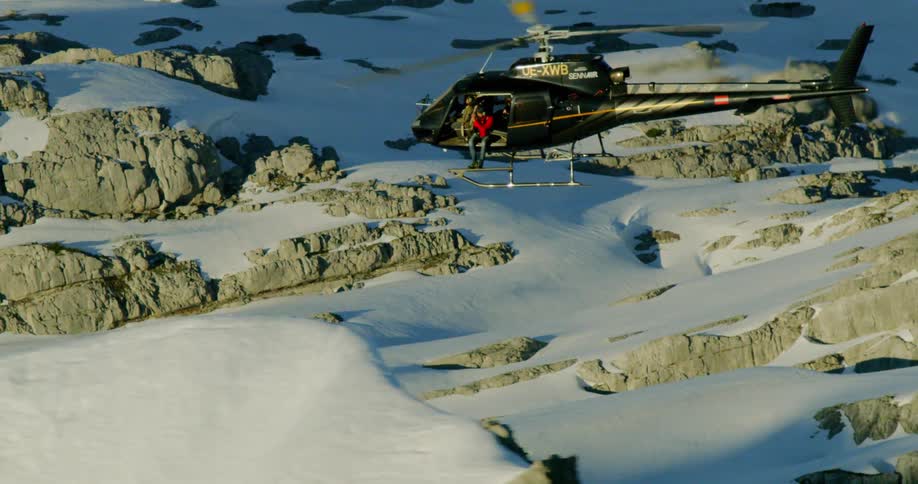 A helicopter flying above icy mountain