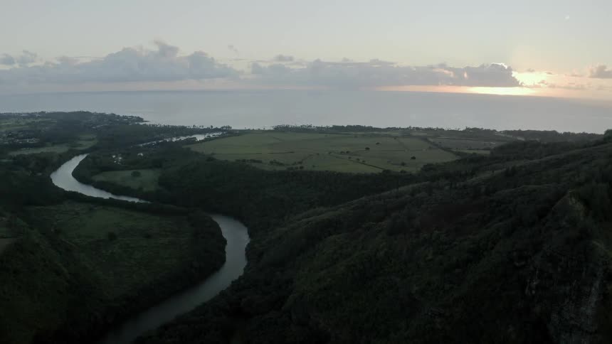 River winds through plains and mountains at sunset