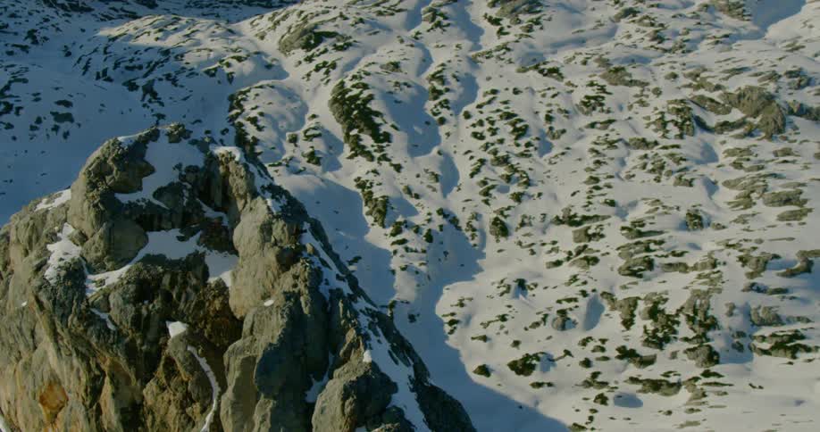 A rocky ridge above a snow covered slope