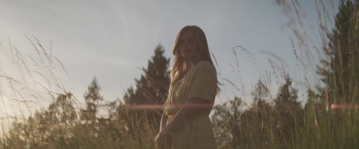 A woman standing in a field of tall grass