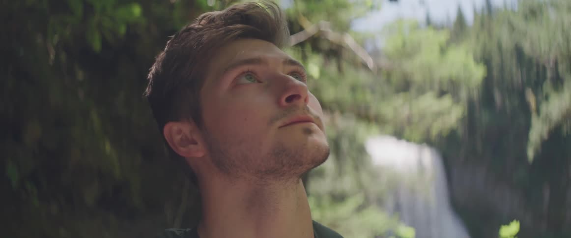 Man look up in the sky in the forest