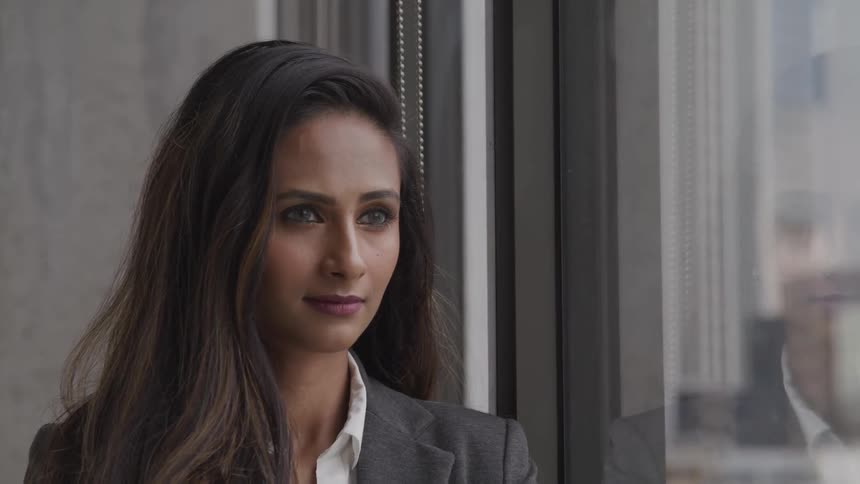 A woman in a business suit staring out of a window