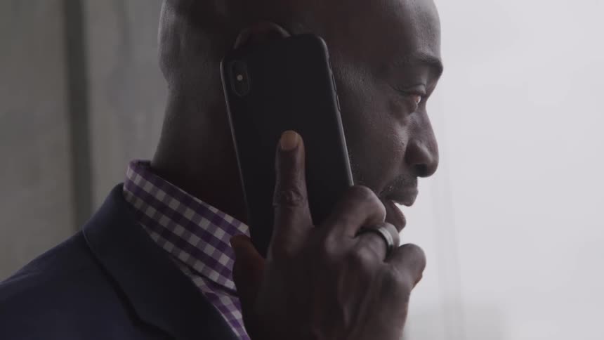 Businessman talking on his cell phone outdoors in a city