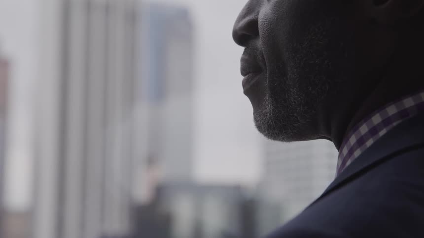 A black man looks out his office window