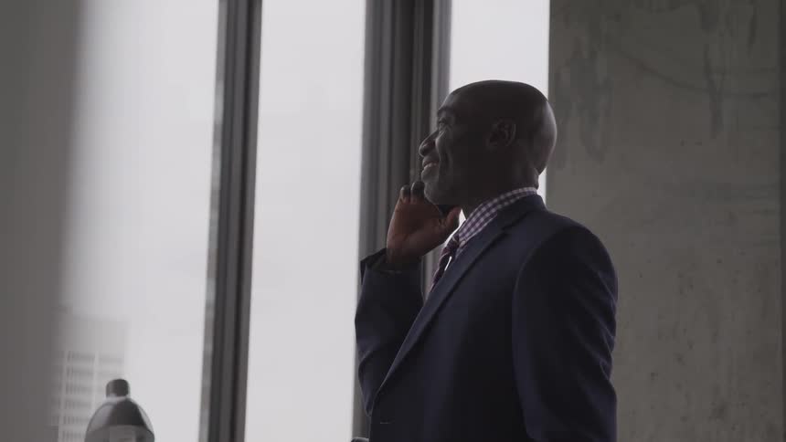 A man wearing a suit is standing in a office building