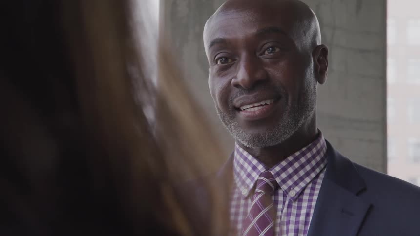 A black man talks to a woman
