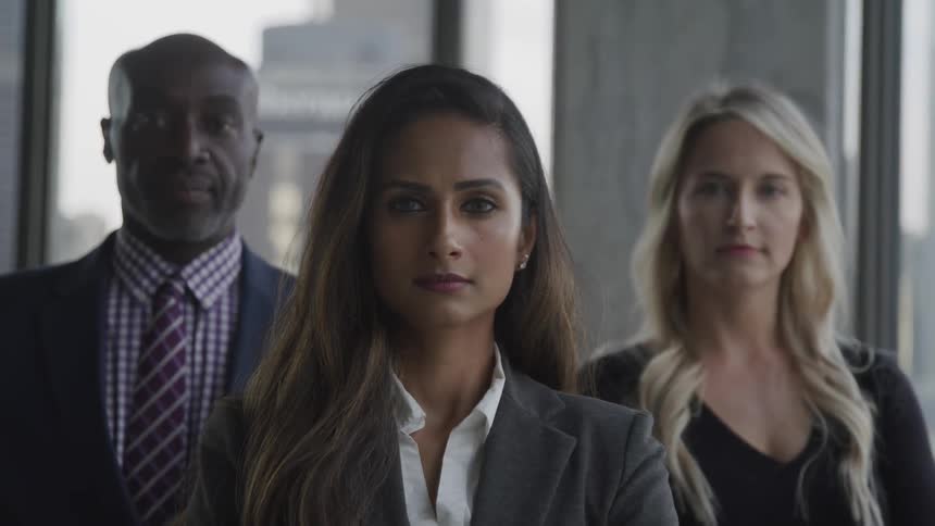 Three people are standing in an office building