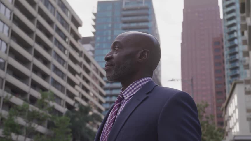 A black man with suit looking at his surroundings