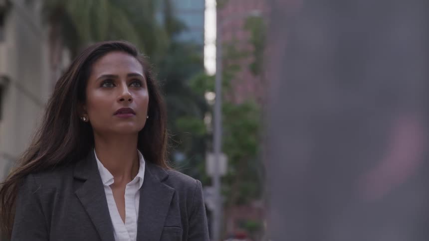 Business woman looking stoically outdoors in a city
