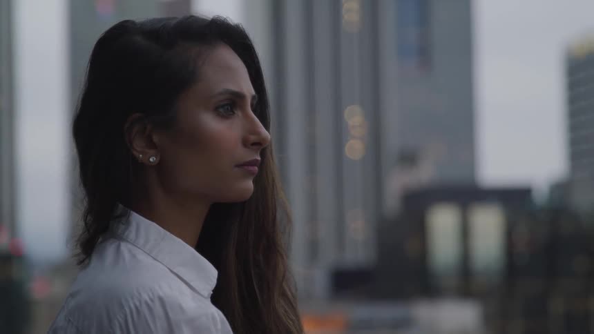 Woman with long brunette hair stands in downtown