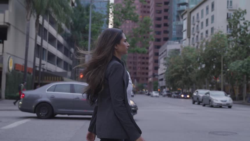 A young woman walks across the street