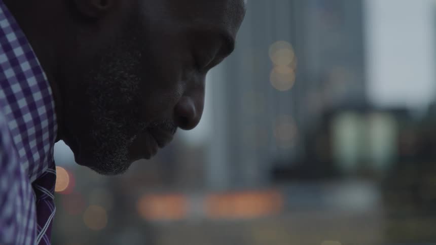 A black an contemplatively thinking on the city