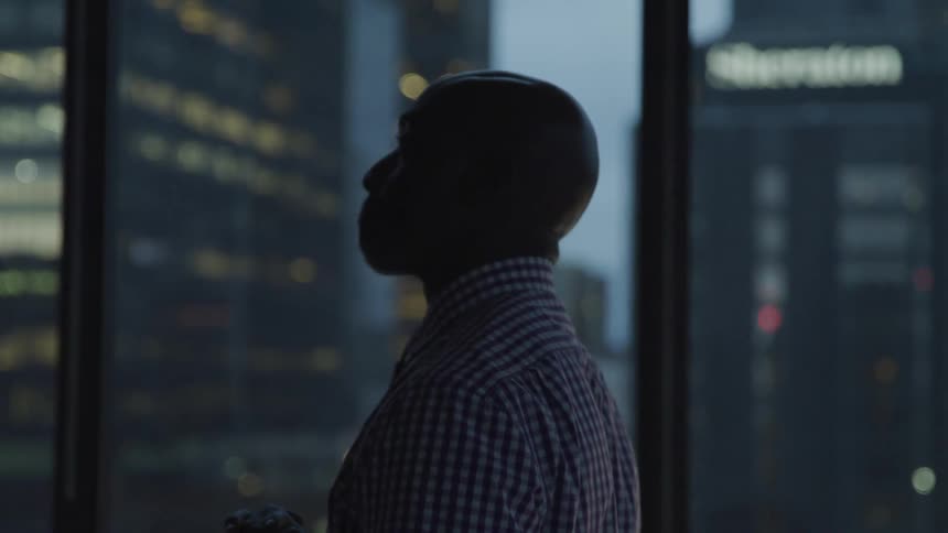 A man walks past the window showing the city