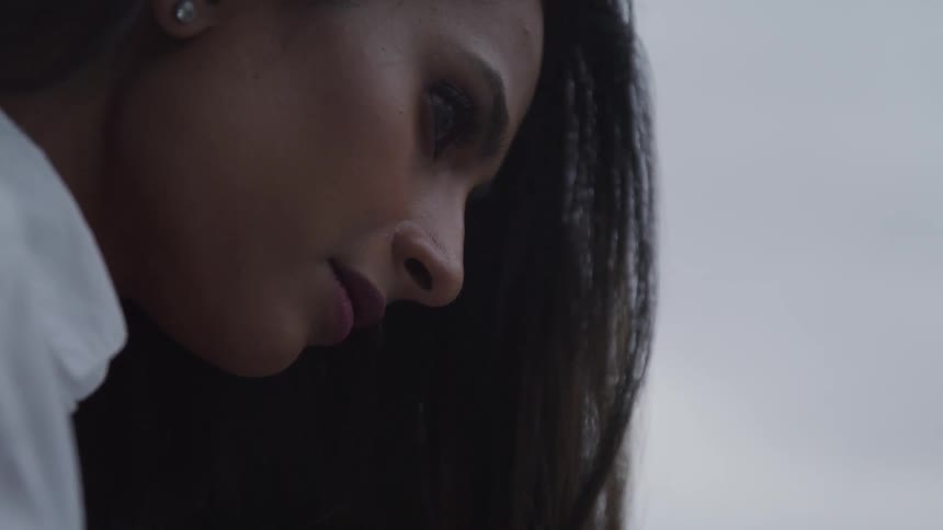 A young woman looks down while deep in thought
