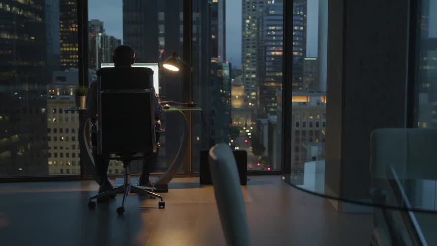 A man works in his high rise office at night
