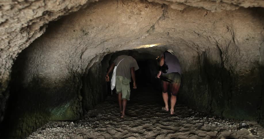 Men enter a deep cave
