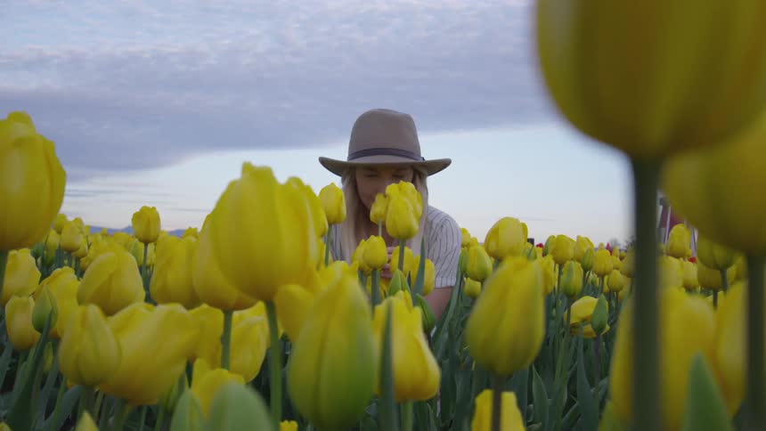 A female sits in a field of tulips