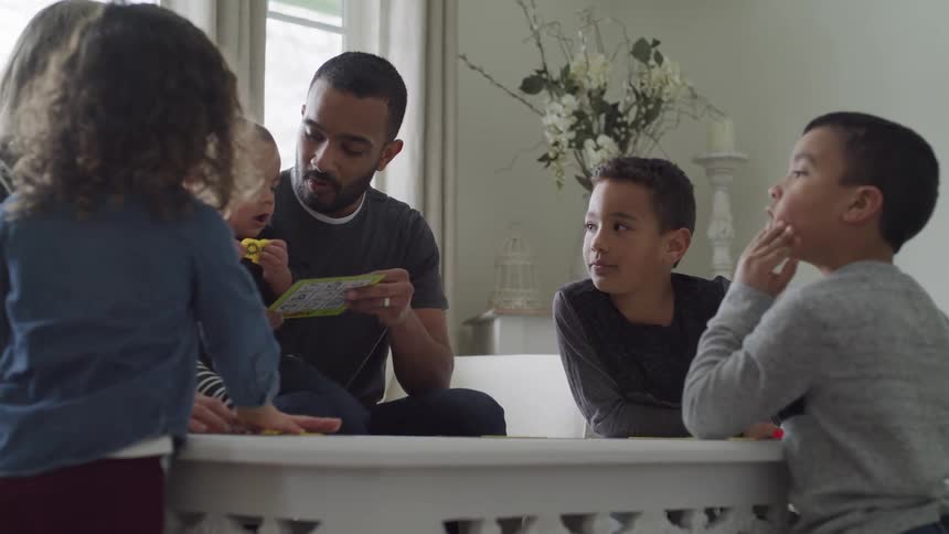 A family sits at a table and plays a game