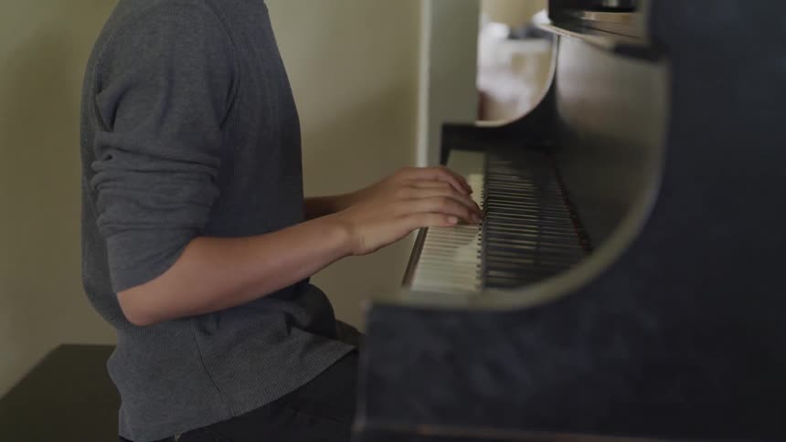 A young man plays the piano