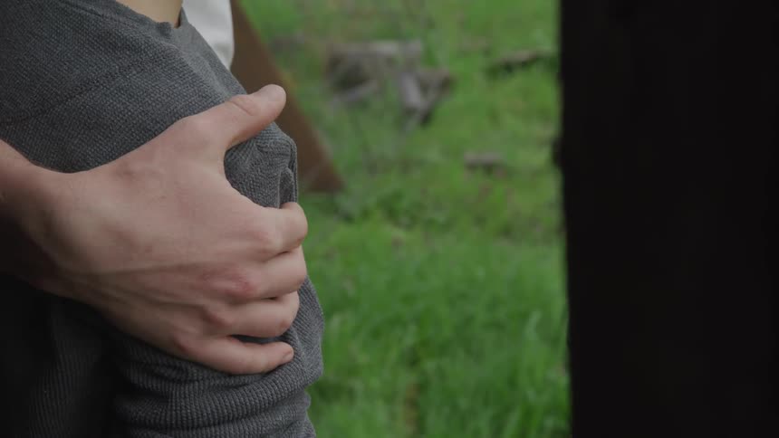 A man rubs a childs arm