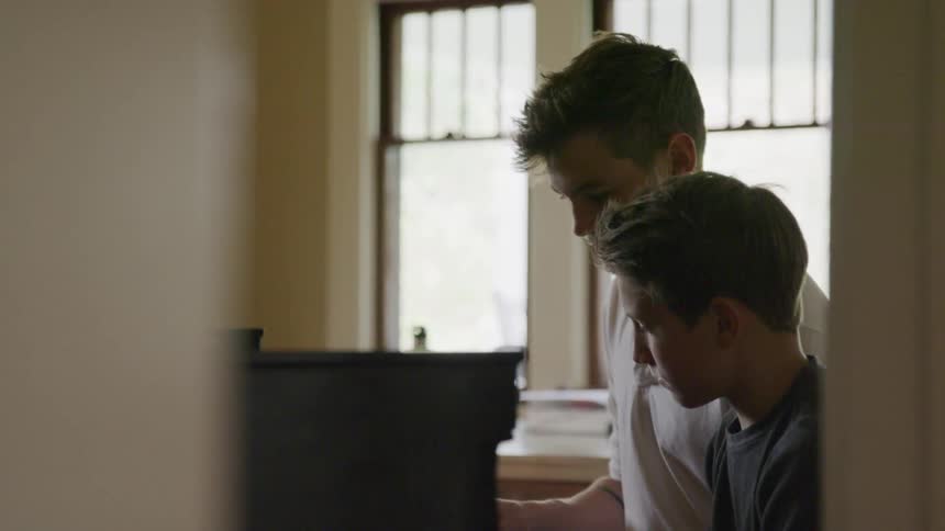 Brothers teaching something to the younger brother
